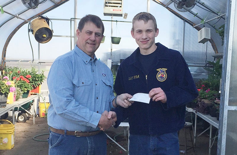 CFS board chairman Charlie Johnson presents United South Central FFA chapter President Alex Warmka with a check for $2,000. The Land O’Lakes Foundation matching funds of $2,000 will be presented at a later date. - Provided