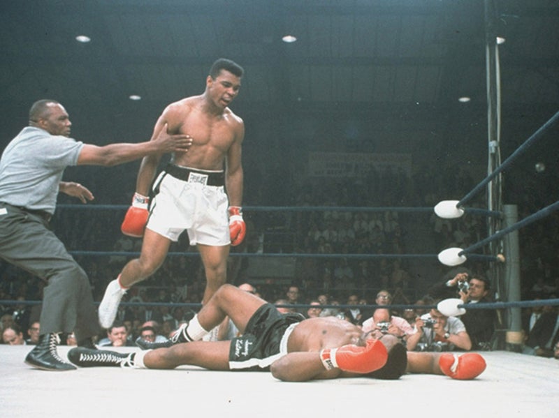 Muhammad Ali is held back by referee Joe Walcott after knocking out Sonny Liston in the first round of their championship bout in Lewiston, Maine, on May 25, 1965. AP via MPR News