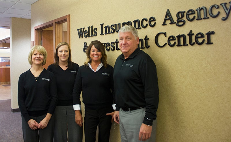 Donna Yokiel stands with Wells Insurance Agency customer service representatives Abby Roberts and Juli Redig and Wells Federal Bank Vice Pesident Chuck Schulenberg. - Sam Wilmes/Albert Lea Tribune