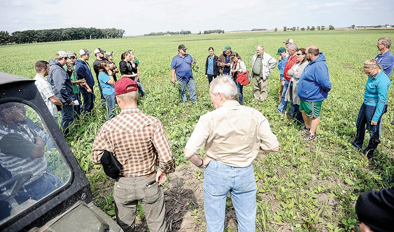 TJ Kartes of Saddle Butte Ag Inc. talks to a tour group about the benefits of cover crops on a field belonging to Tom Cotter on Thursday afternoon. - Eric Johnson/Albert Lea Tribune