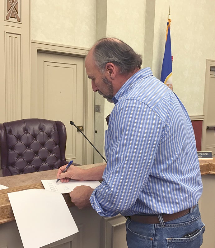Shell Rock River Watershed District Board Chairman Dan DeBoer signs paperwork after a special meeting last week. Provided