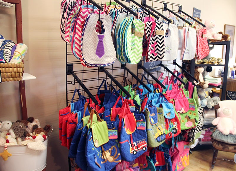 Barnyard Kids offers many embroidered children's items, including these bibs and backpacks. Sarah Stultz/Albert Lea Tribune