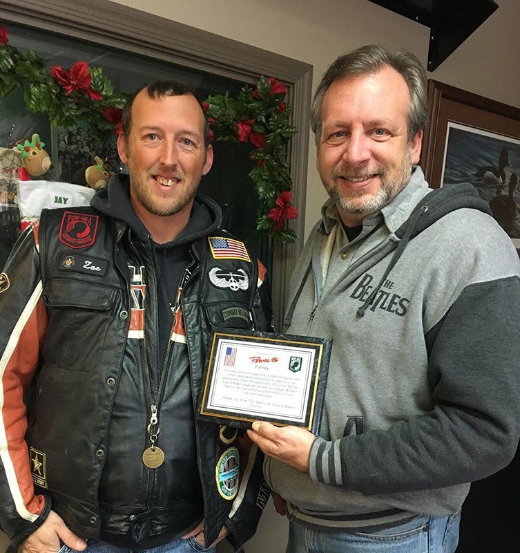 Ron Hunter accepts a plaque from Zac Stuart of the American Legion Post Riders Post 91, thanking Hometown Broadcasting for its continued support and dedicated commitment of fundraising events throughout 2016 for area veterans and their families. - Provided